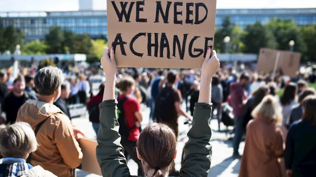 Womanholdingweneedachangeposter_2023